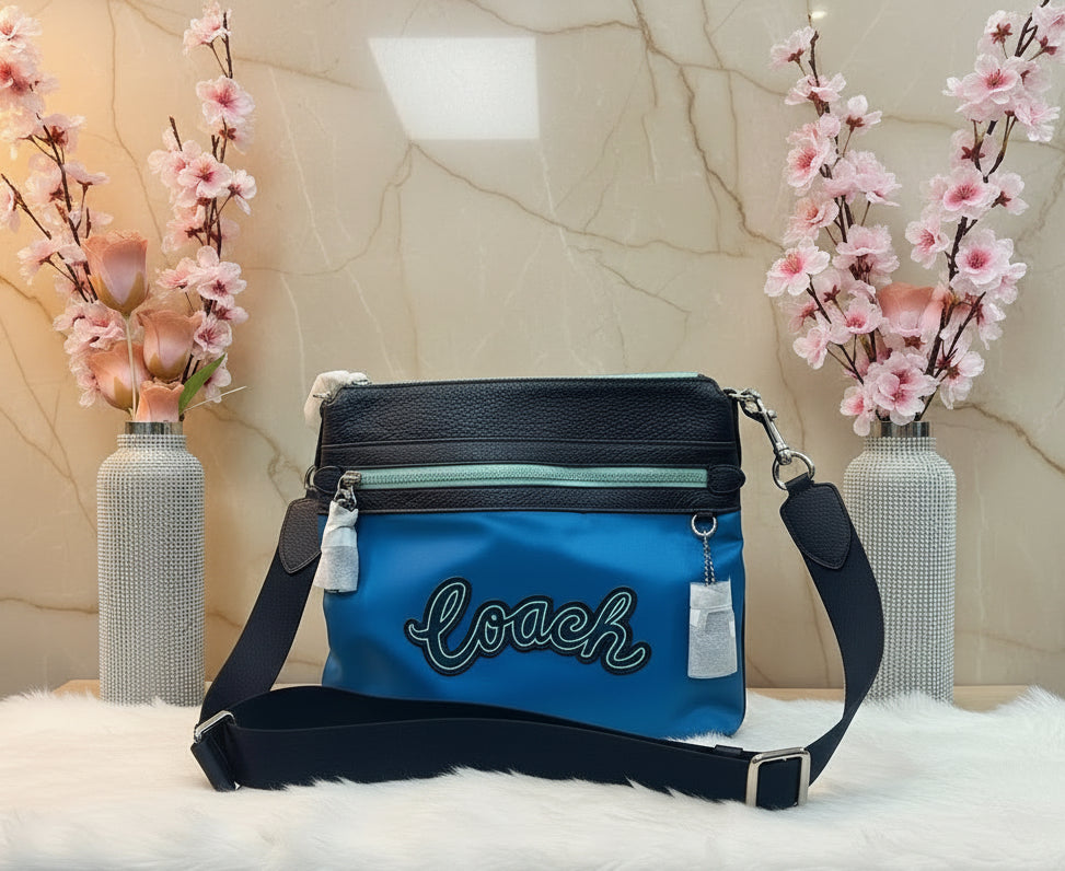 حقيبة كروسبودي من كوتش فال فايل - نايلون/جلد محبب، لون أزرق سماوي متعدد الألوان