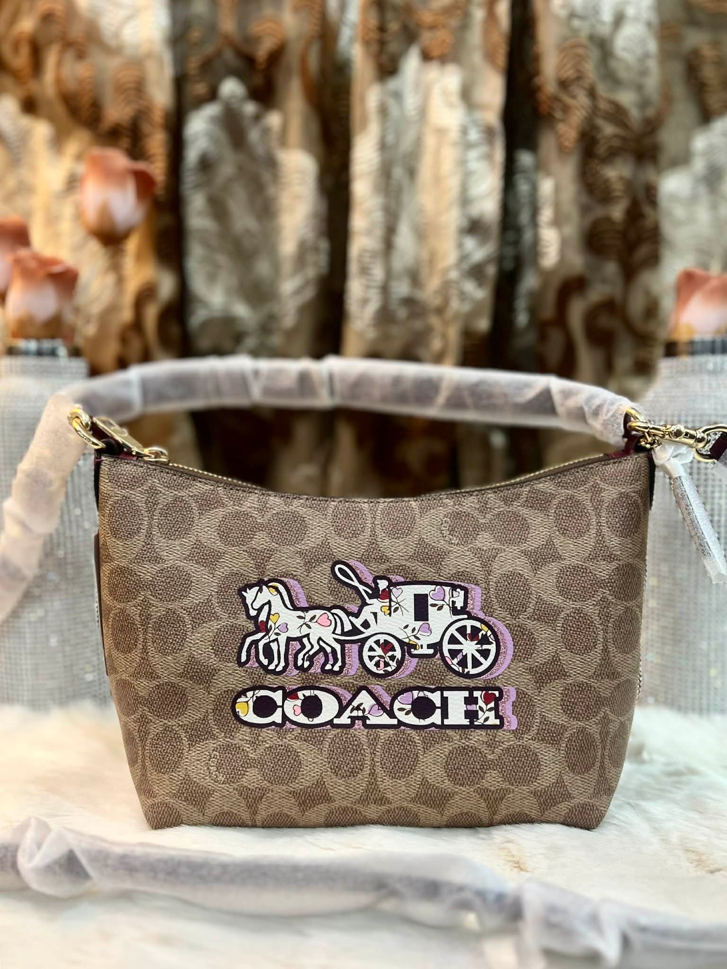 حقيبة كتف/حقيبة كروس بودي من كوتش بايتون بنقشة الحصان والعربة المميزة