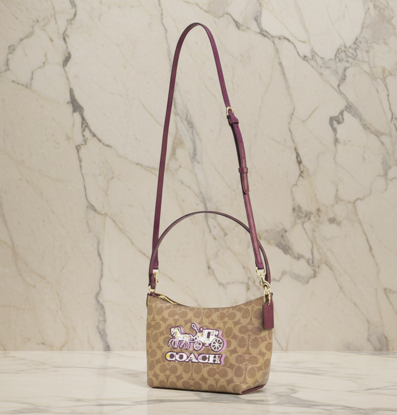 حقيبة كتف/حقيبة كروس بودي من كوتش بايتون بنقشة الحصان والعربة المميزة