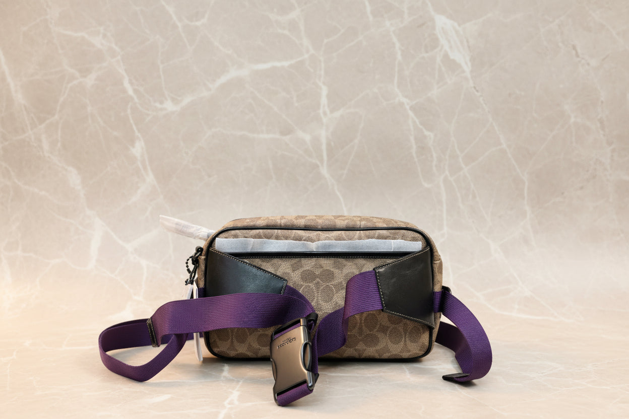 حقيبة خصر/حقيبة جسم محدودة الإصدار مطبوعة بشعار كوتش، مصنوعة من قماش الكانفاس البني المميز.