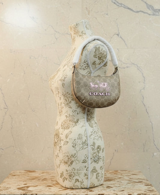 حقيبة كتف صغيرة من كوتش بايتون، متوفرة فقط بنقشة الحصان والعربة المميزة.