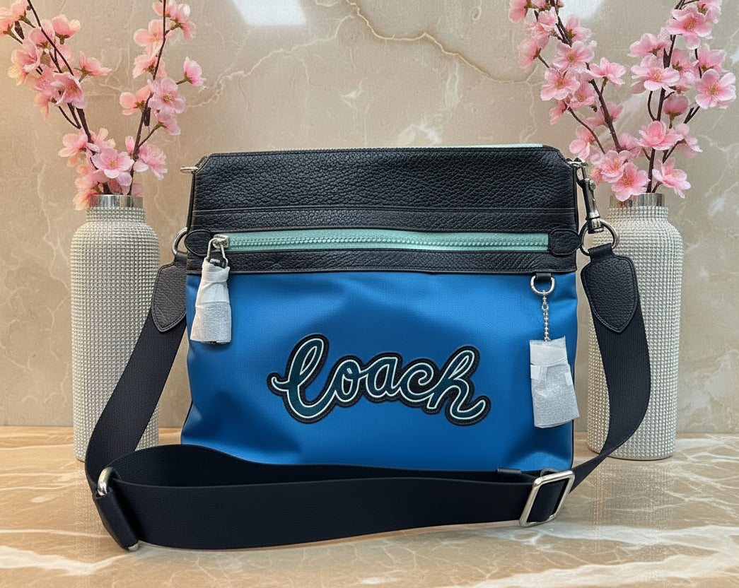 حقيبة كروسبودي من كوتش فال فايل - نايلون/جلد محبب، لون أزرق سماوي متعدد الألوان