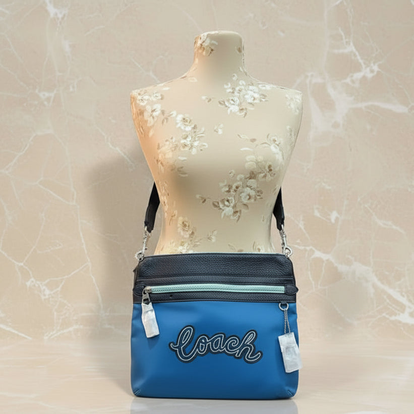 حقيبة كروسبودي من كوتش فال فايل - نايلون/جلد محبب، لون أزرق سماوي متعدد الألوان