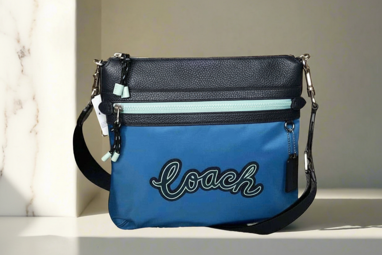 حقيبة كروسبودي من كوتش فال فايل - نايلون/جلد محبب، لون أزرق سماوي متعدد الألوان