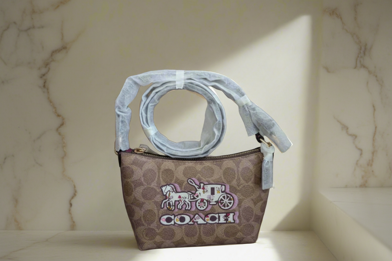 حقيبة كتف/حقيبة كروس بودي من كوتش بايتون بنقشة الحصان والعربة المميزة