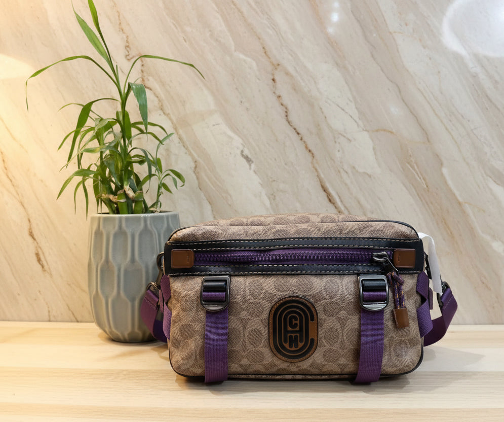 حقيبة خصر/حقيبة جسم محدودة الإصدار مطبوعة بشعار كوتش، مصنوعة من قماش الكانفاس البني المميز.