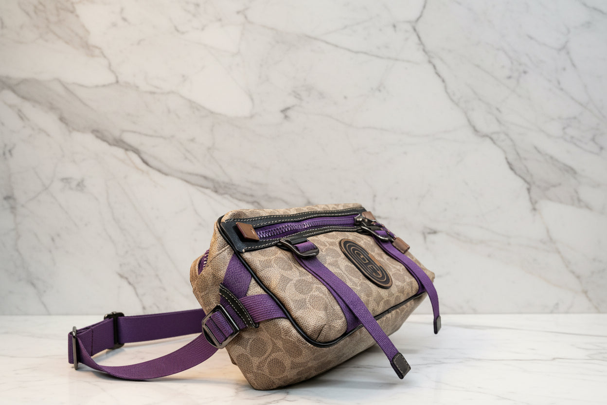 حقيبة خصر/حقيبة جسم محدودة الإصدار مطبوعة بشعار كوتش، مصنوعة من قماش الكانفاس البني المميز.