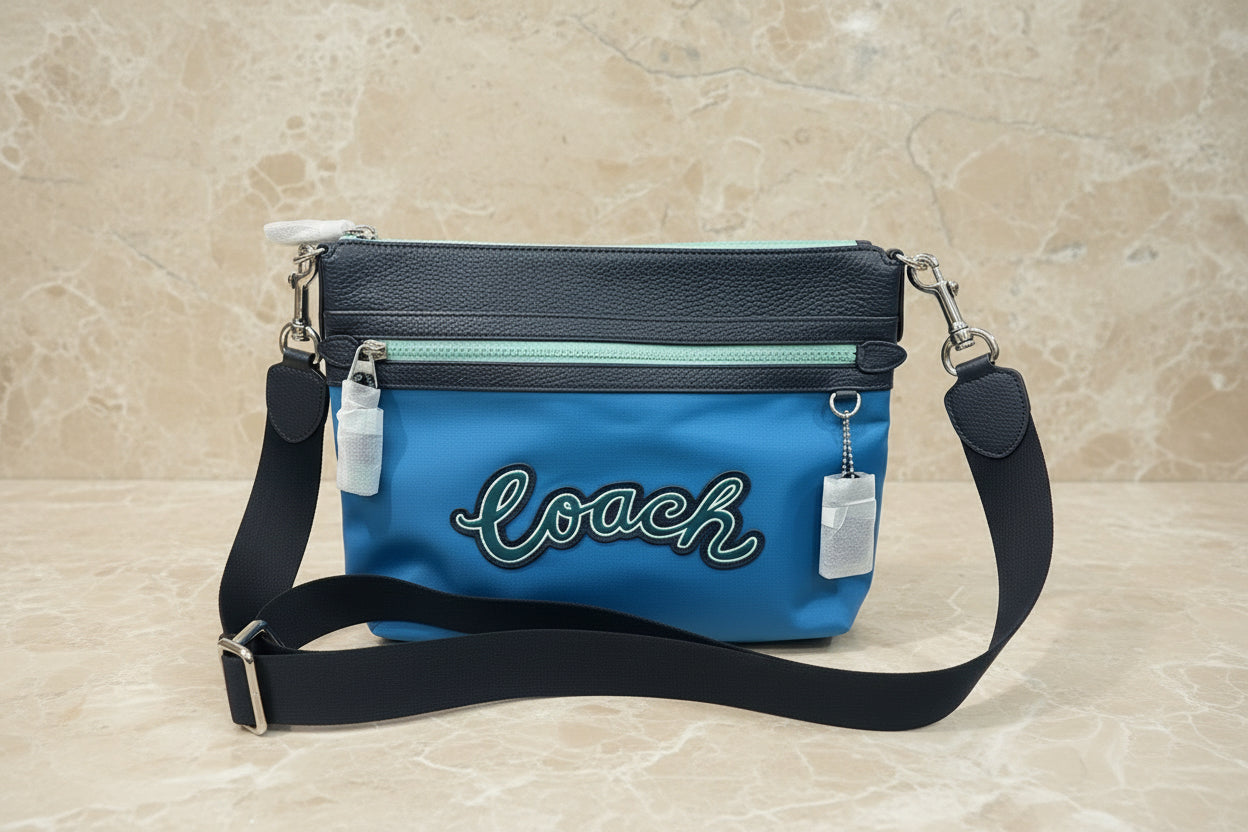 حقيبة كروسبودي من كوتش فال فايل - نايلون/جلد محبب، لون أزرق سماوي متعدد الألوان