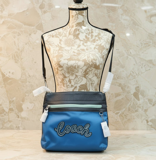 حقيبة كروسبودي من كوتش فال فايل - نايلون/جلد محبب، لون أزرق سماوي متعدد الألوان