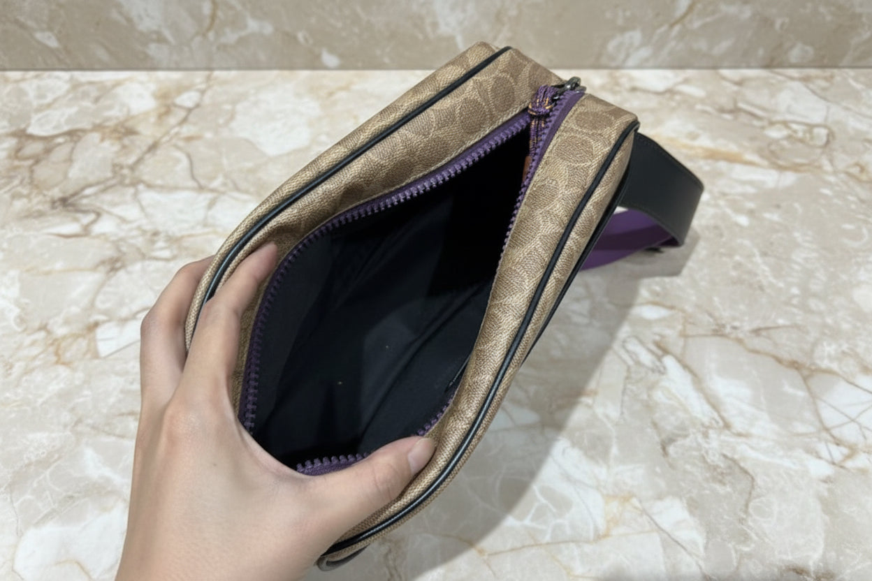 حقيبة خصر/حقيبة جسم محدودة الإصدار مطبوعة بشعار كوتش، مصنوعة من قماش الكانفاس البني المميز.